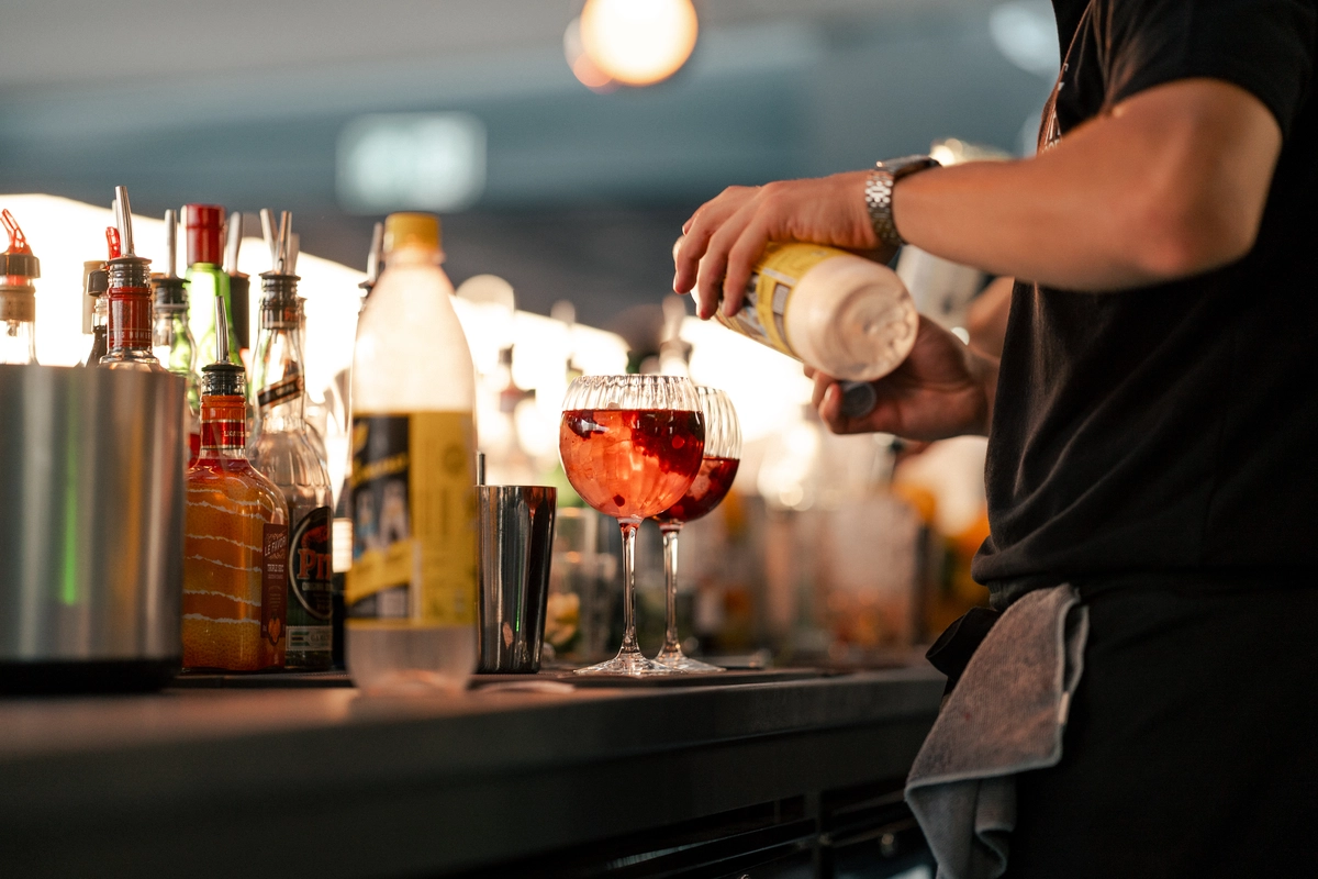 Unsere aufmerksamen Mitarbeiter gießen erfrischende Getränke an der Bar ein, um deine Wünsche zu erfüllen.